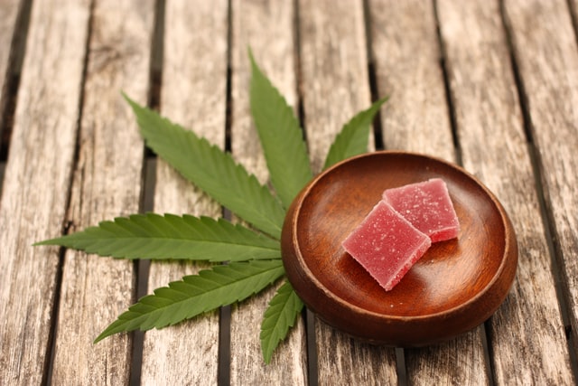cannabis edibles in dish near pot leaf