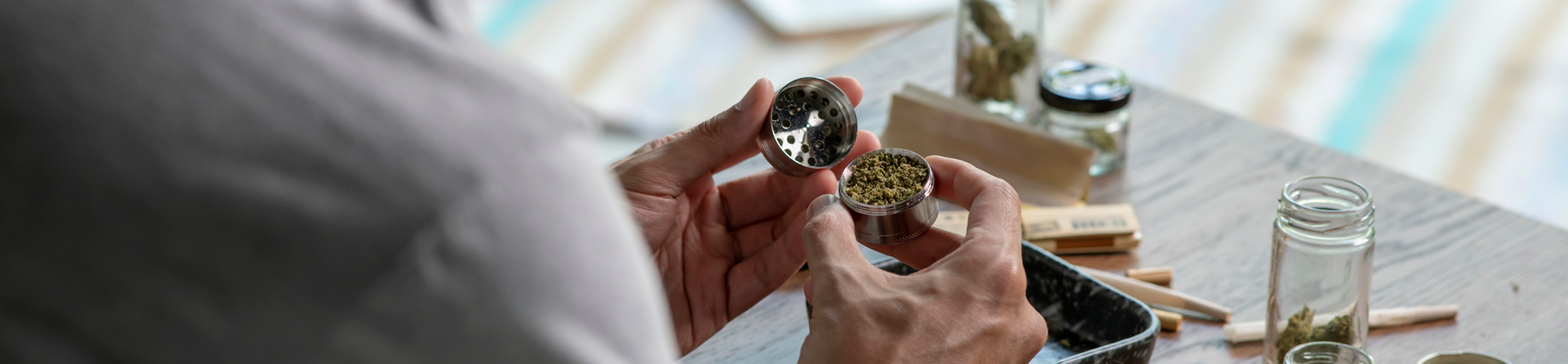 man grinding cannabis he got at a reduced cost with a medical card