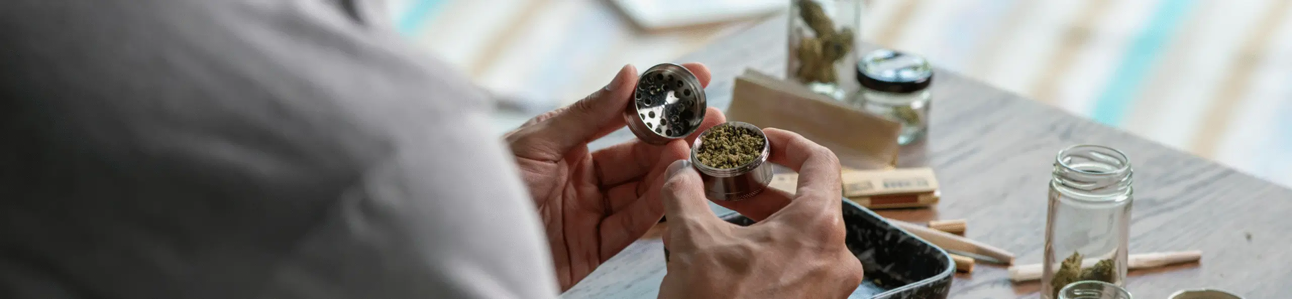 man grinding cannabis he got at a reduced cost with a medical card